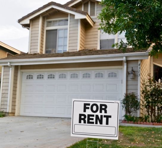 A "For Rent" sign in front of a house, perfect for airbnb property management in england.