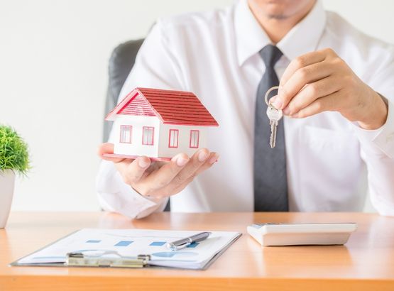 Agent holding a model house and keys, providing expert short term let management services.